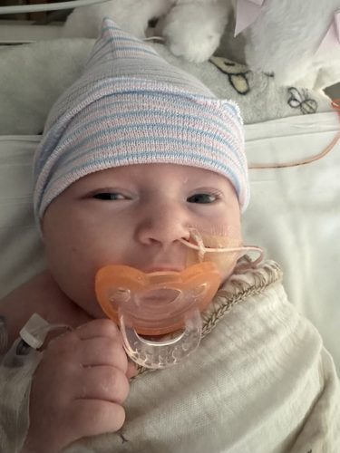 Audrey May Wendler with a pacifier, giving the most determined fist bump